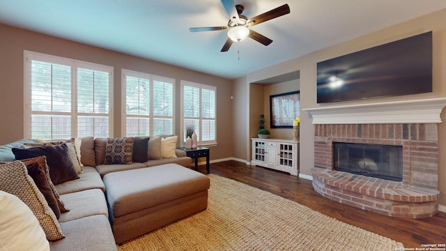 living room featuring a fireplace, dark hardwood / wood-style floors, ceiling fan, and a healthy amount of sunlight