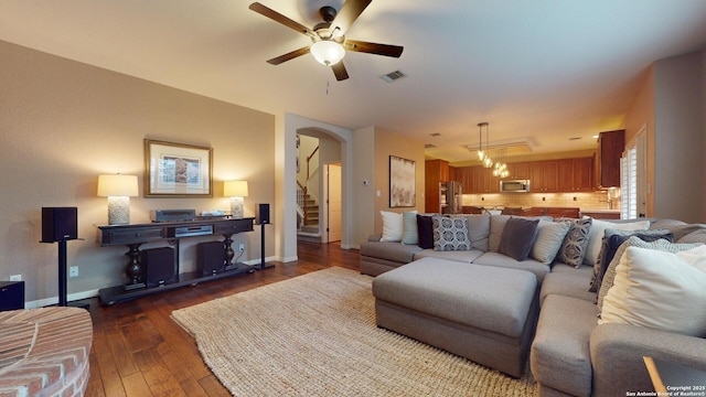 living room featuring ceiling fan and dark hardwood / wood-style floors