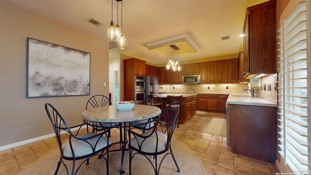 dining space with a notable chandelier and sink