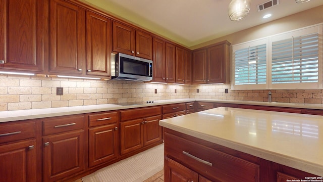 kitchen featuring tasteful backsplash, black electric cooktop, sink, and light tile patterned flooring