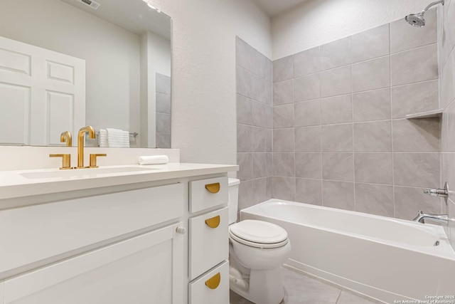 full bathroom with tile patterned flooring, tiled shower / bath combo, toilet, and vanity