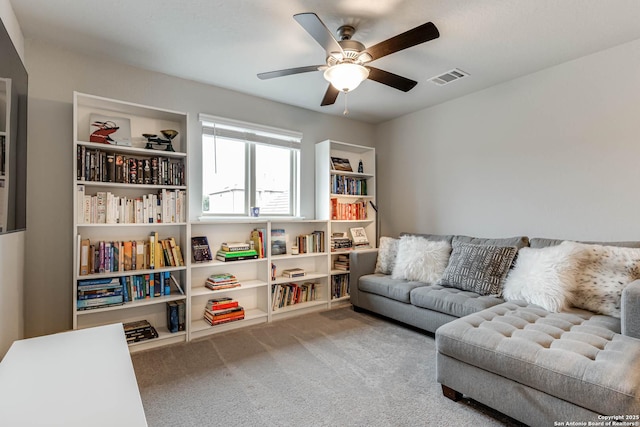 living area featuring carpet floors and ceiling fan