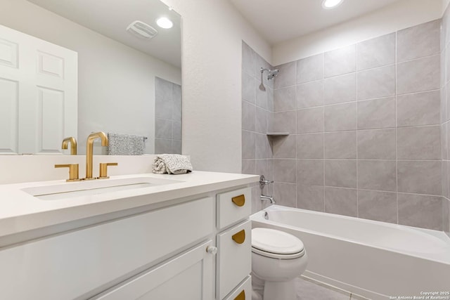 full bathroom featuring toilet, vanity, and tiled shower / bath