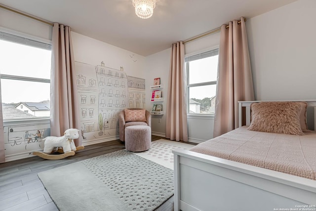 bedroom featuring hardwood / wood-style flooring and an inviting chandelier