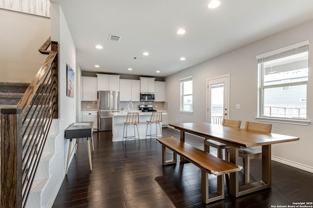 dining space with sink and dark wood-type flooring