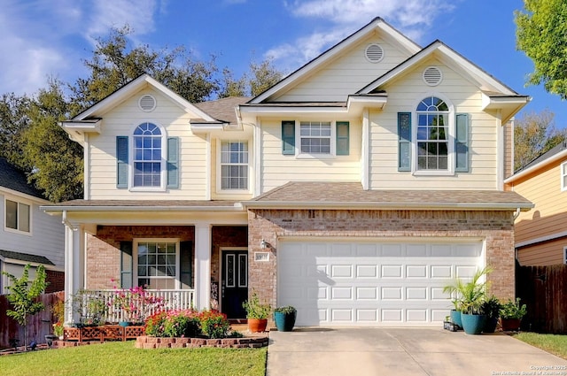 view of front of home with a garage, a front lawn, and covered porch