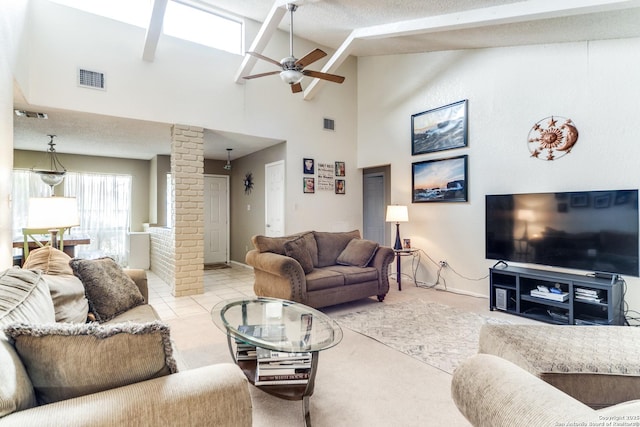 living room featuring ceiling fan, ornate columns, a textured ceiling, and high vaulted ceiling