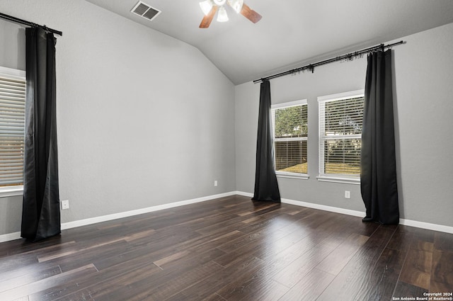 empty room featuring dark hardwood / wood-style flooring, vaulted ceiling, and ceiling fan