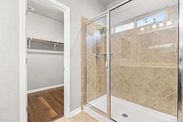 bathroom featuring a shower with door