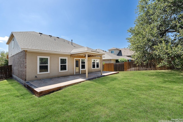 back of property with a lawn and a patio area