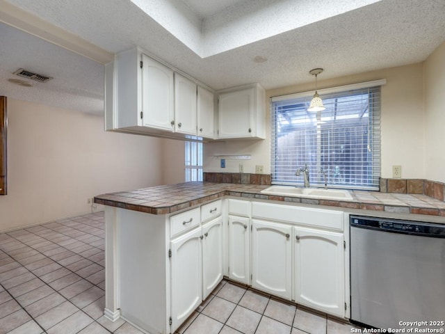 kitchen with sink, tile countertops, decorative light fixtures, dishwasher, and kitchen peninsula