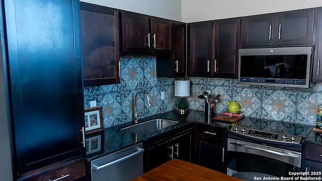 kitchen with backsplash, sink, dark stone counters, and appliances with stainless steel finishes