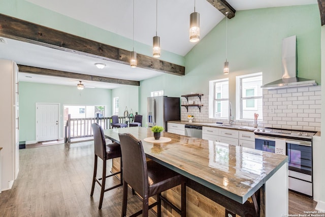 kitchen with exhaust hood, hanging light fixtures, tasteful backsplash, white cabinetry, and stainless steel appliances