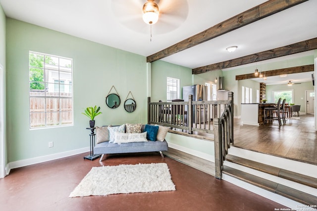 living area with beam ceiling and ceiling fan