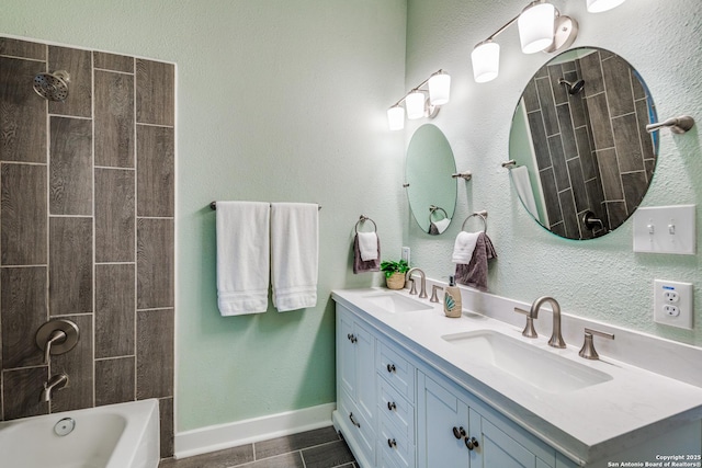 bathroom featuring tile patterned flooring, vanity, and tiled shower / bath