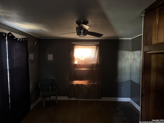 interior space with dark hardwood / wood-style floors, ceiling fan, and crown molding