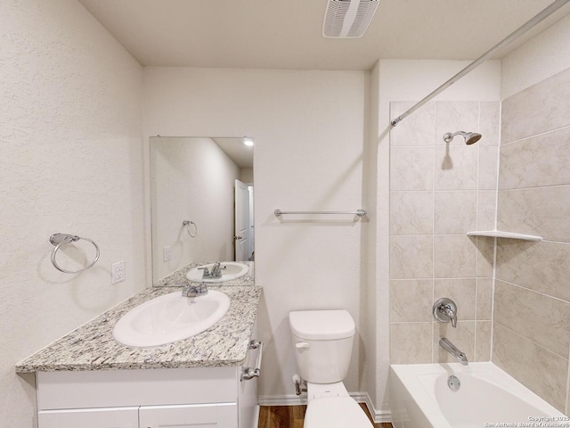 full bathroom with vanity, toilet, and tiled shower / bath combo