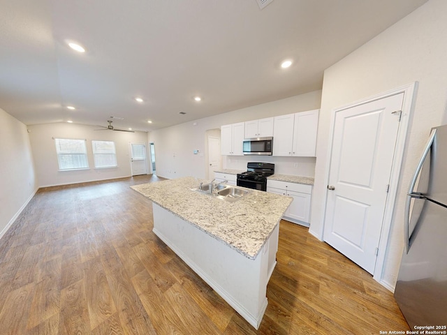 kitchen featuring stainless steel appliances, ceiling fan, sink, white cabinetry, and an island with sink