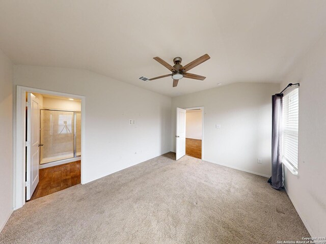 unfurnished bedroom featuring carpet, vaulted ceiling, and ceiling fan