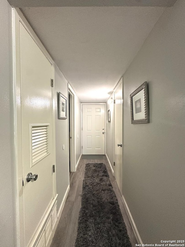 hallway with dark wood-type flooring