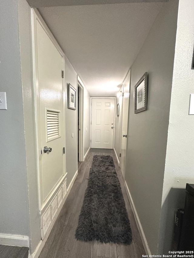 hallway with dark hardwood / wood-style floors