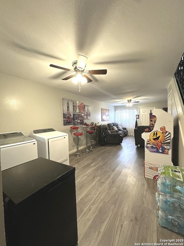 laundry room featuring separate washer and dryer, ceiling fan, a textured ceiling, and hardwood / wood-style flooring