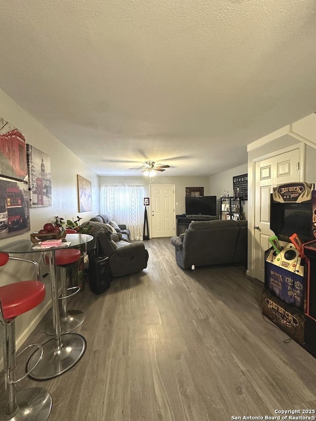 living room featuring hardwood / wood-style floors, a textured ceiling, and ceiling fan