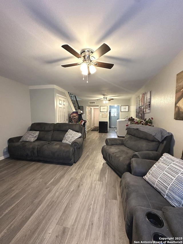 living room featuring hardwood / wood-style flooring and ceiling fan