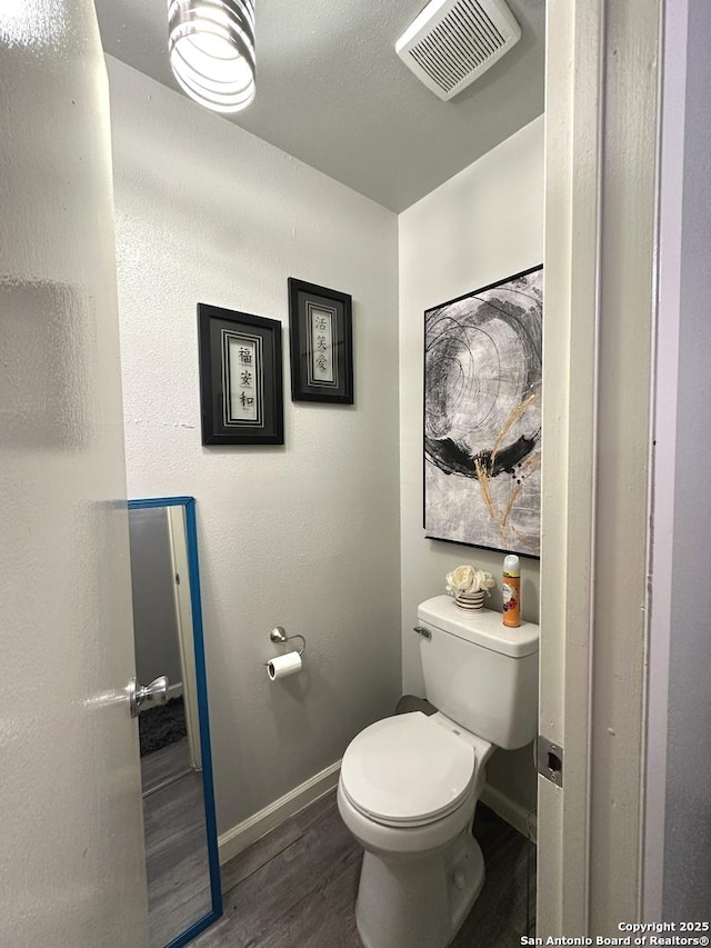 bathroom with toilet and wood-type flooring