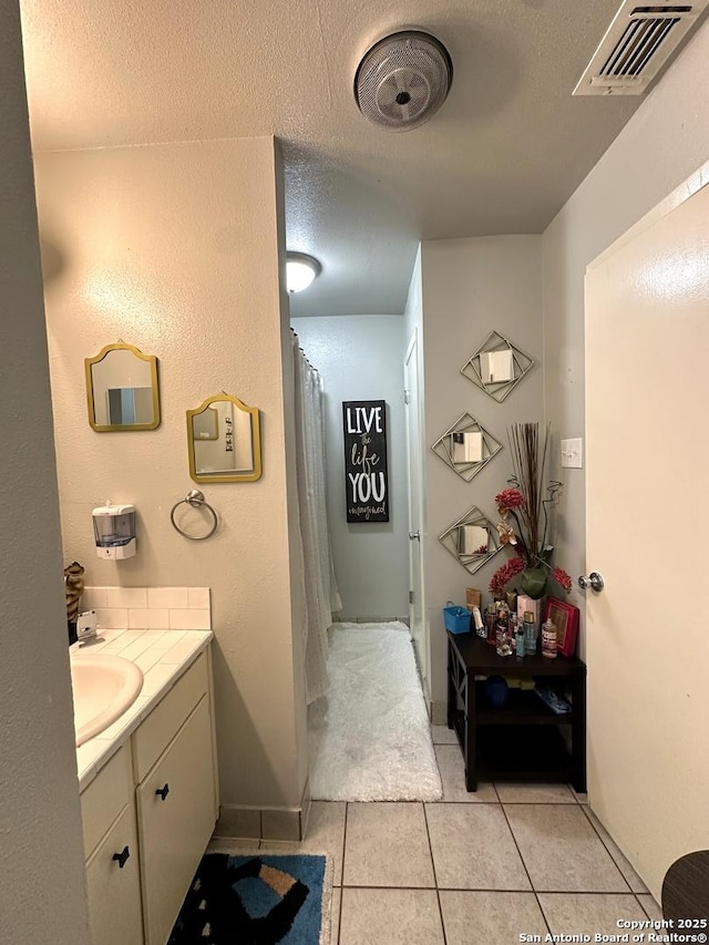 bathroom featuring tile patterned flooring, a textured ceiling, and vanity