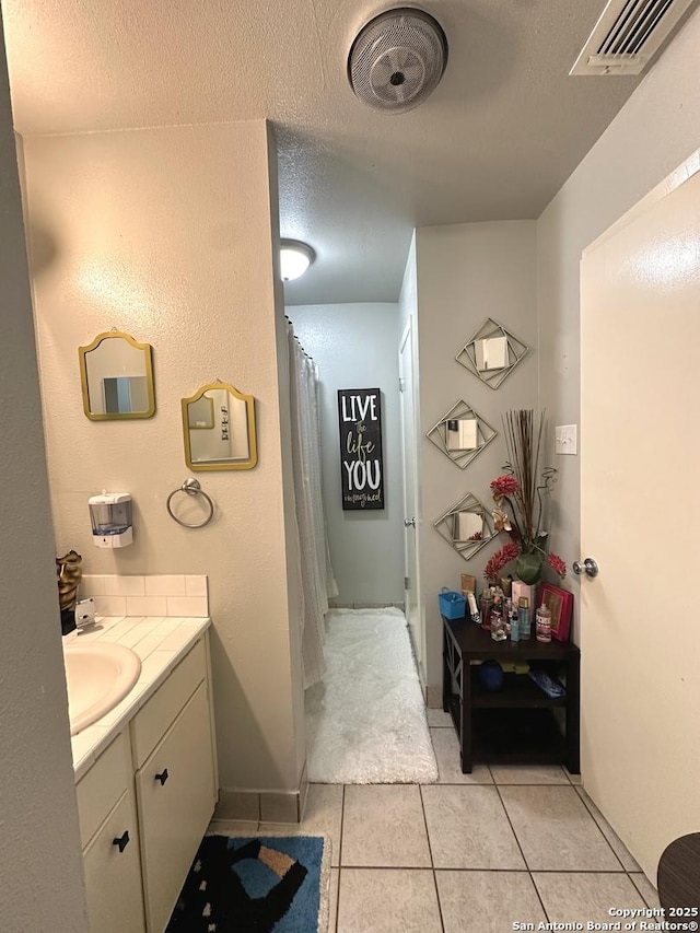 bathroom with vanity, a textured ceiling, and tile patterned floors