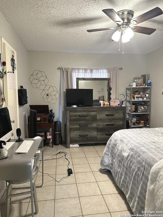 tiled bedroom with ceiling fan and a textured ceiling