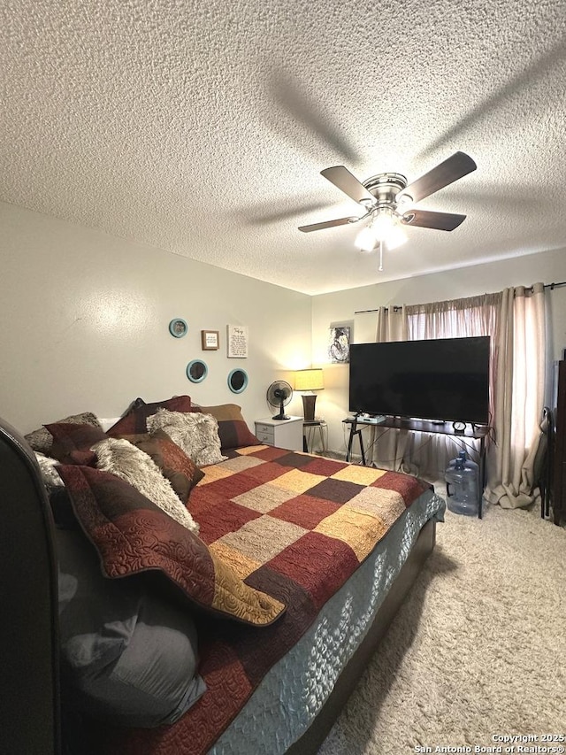 carpeted bedroom with ceiling fan and a textured ceiling