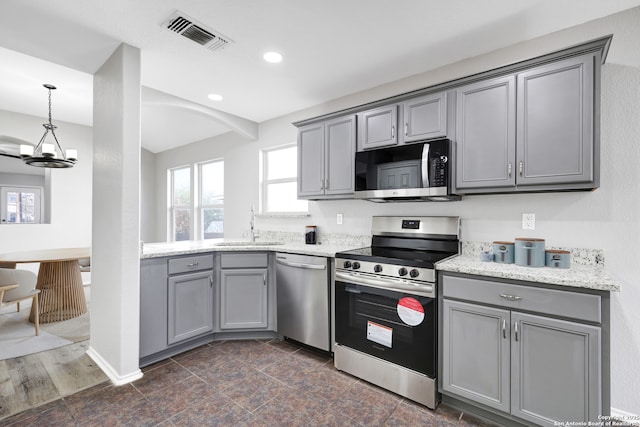 kitchen featuring a notable chandelier, gray cabinets, sink, and stainless steel appliances