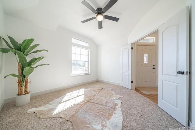 foyer featuring carpet flooring, vaulted ceiling, and ceiling fan