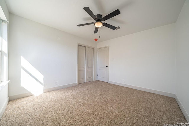 empty room with ceiling fan and carpet