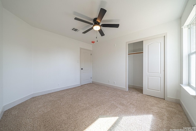 unfurnished bedroom featuring ceiling fan, a closet, and light colored carpet