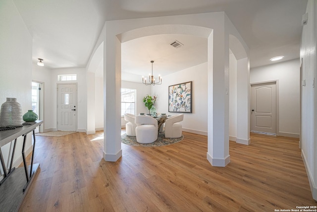 foyer featuring wood-type flooring and an inviting chandelier