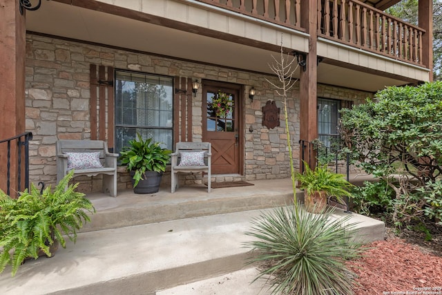 doorway to property featuring a balcony and covered porch