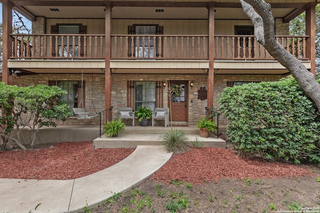 exterior space with covered porch and a balcony