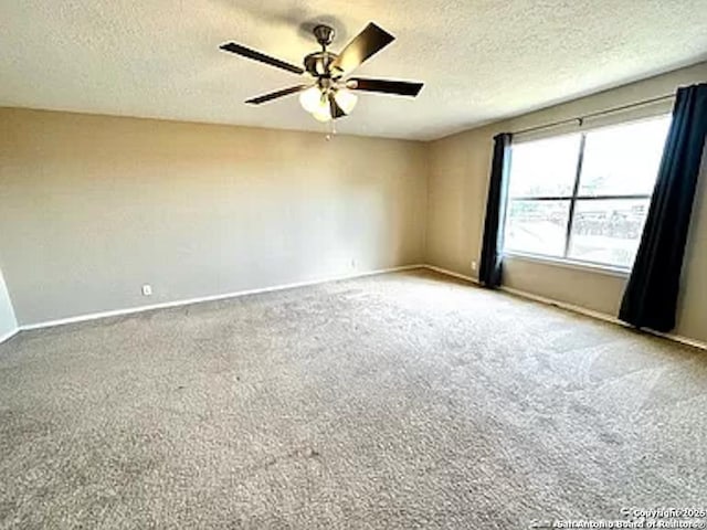 carpeted spare room with a textured ceiling and ceiling fan