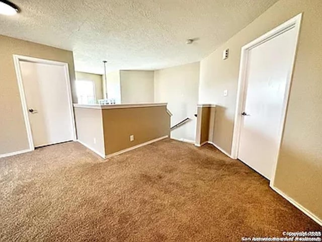 carpeted spare room featuring a textured ceiling