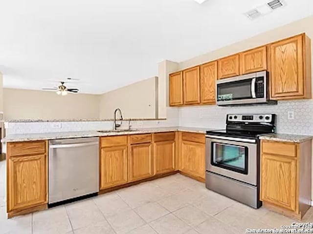 kitchen featuring ceiling fan, sink, stainless steel appliances, kitchen peninsula, and light tile patterned floors