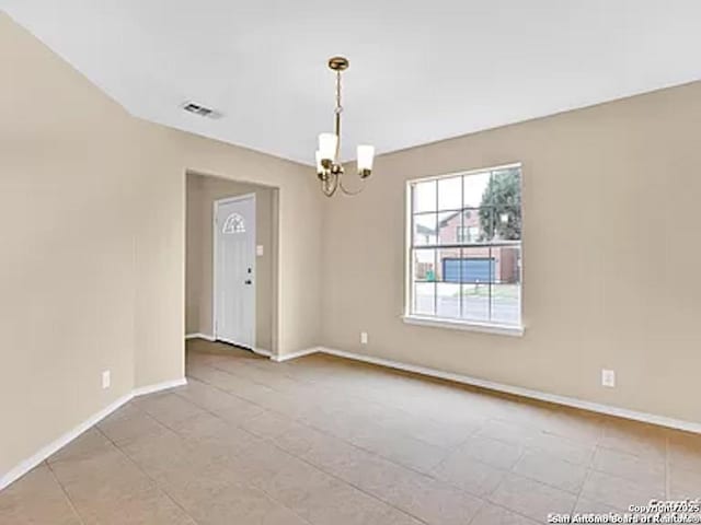 unfurnished room with light tile patterned floors and an inviting chandelier