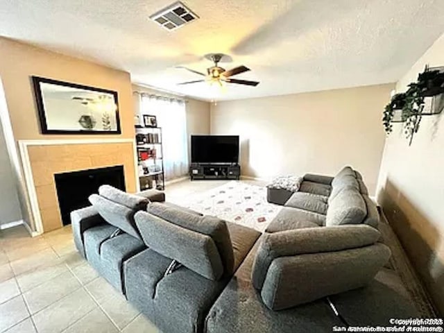 tiled living room with ceiling fan and a textured ceiling