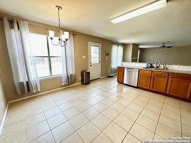 kitchen with stainless steel dishwasher, ceiling fan with notable chandelier, a textured ceiling, sink, and pendant lighting