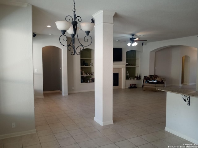 unfurnished dining area with ceiling fan with notable chandelier, built in features, and light tile patterned floors