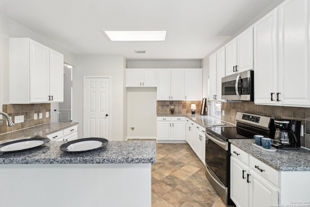 kitchen featuring white cabinets, sink, appliances with stainless steel finishes, and tasteful backsplash