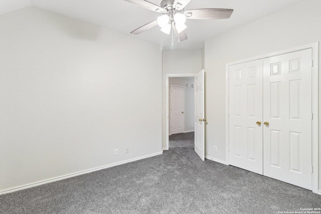 unfurnished bedroom featuring ceiling fan, dark carpet, vaulted ceiling, and a closet