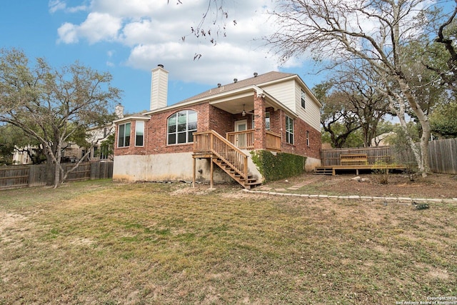 back of property with a yard and a wooden deck